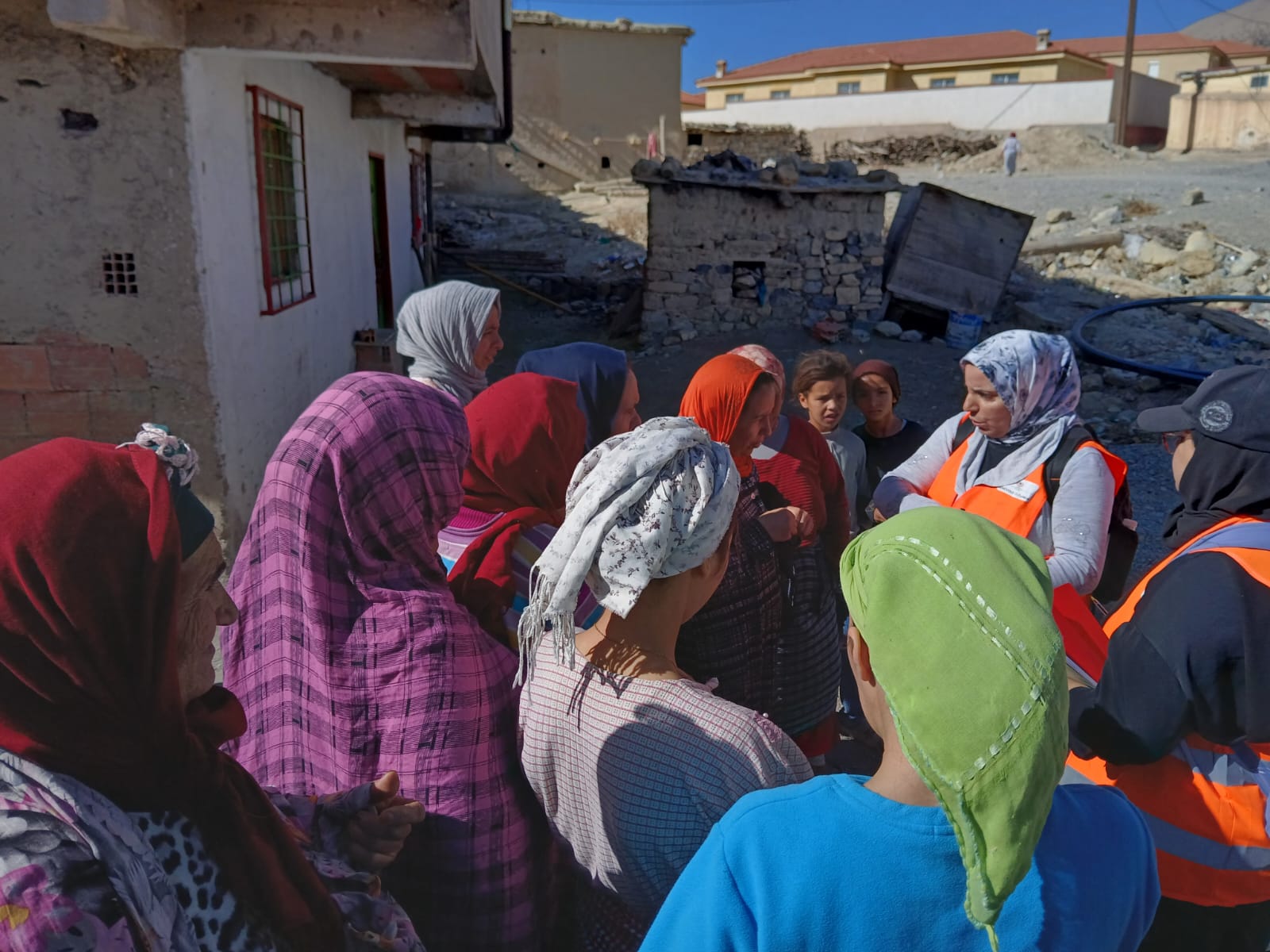 Premiers contacts dans un douar de Agoudime, Karima (gilet orange) est très sollicitée. © Franceska Gilardi